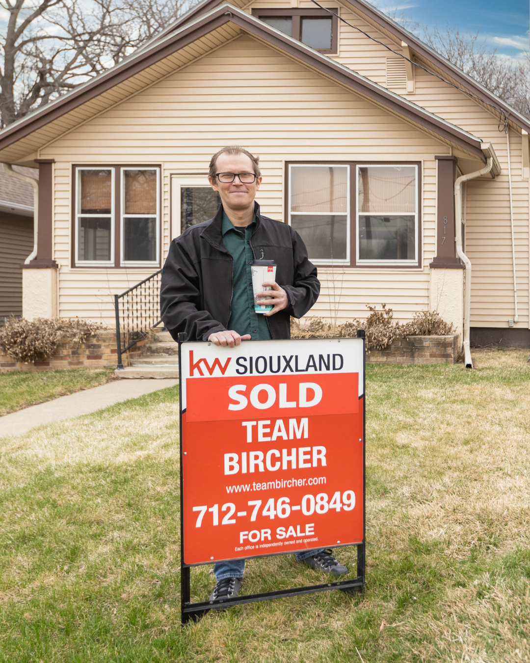 Buyer Michael in front of 817 South Fairmount Street in Sioux City, Iowa holding a sold sign with Team Bircher, Keller Williams Siouxland