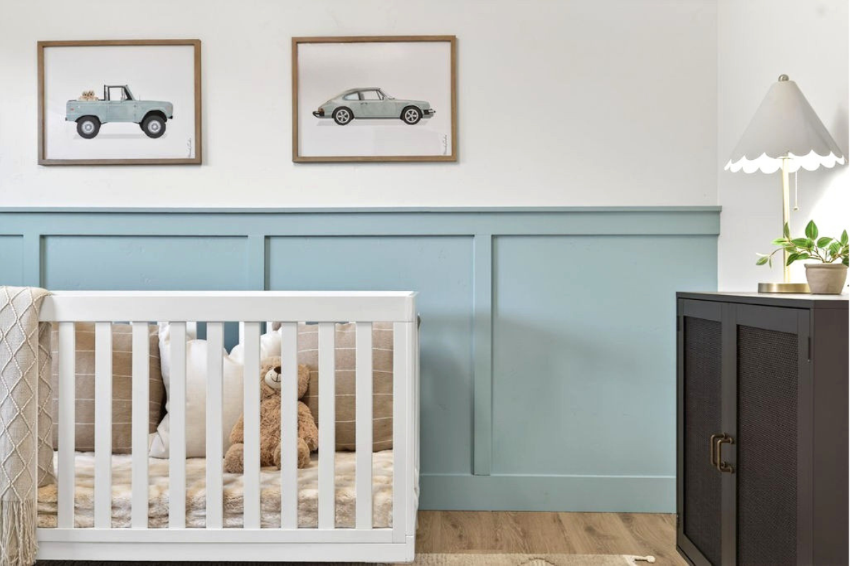 Bright nursery with white crib, blue paneled wall, framed vintage car art, teddy bear, and modern decor, representing growing families and changing home needs.