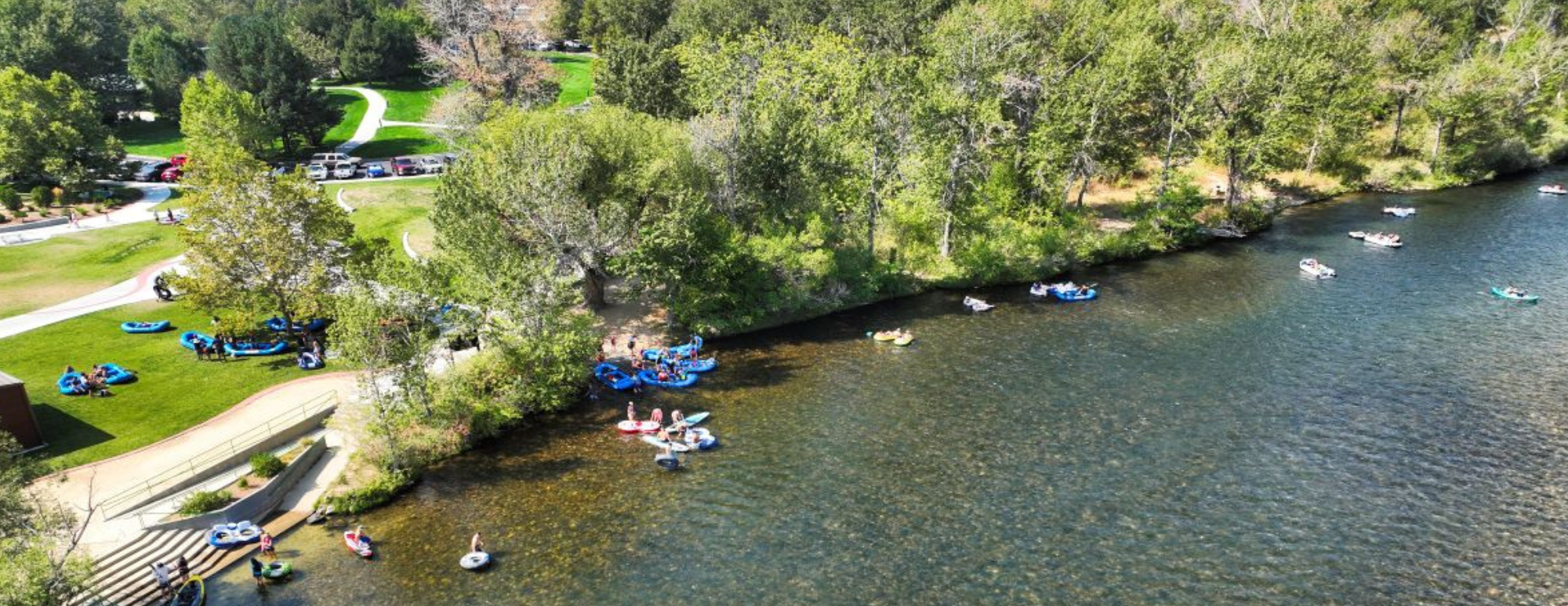 Aerial view of Barber Park in Boise, Idaho, with people floating the Boise River and enjoying the Greenbelt.