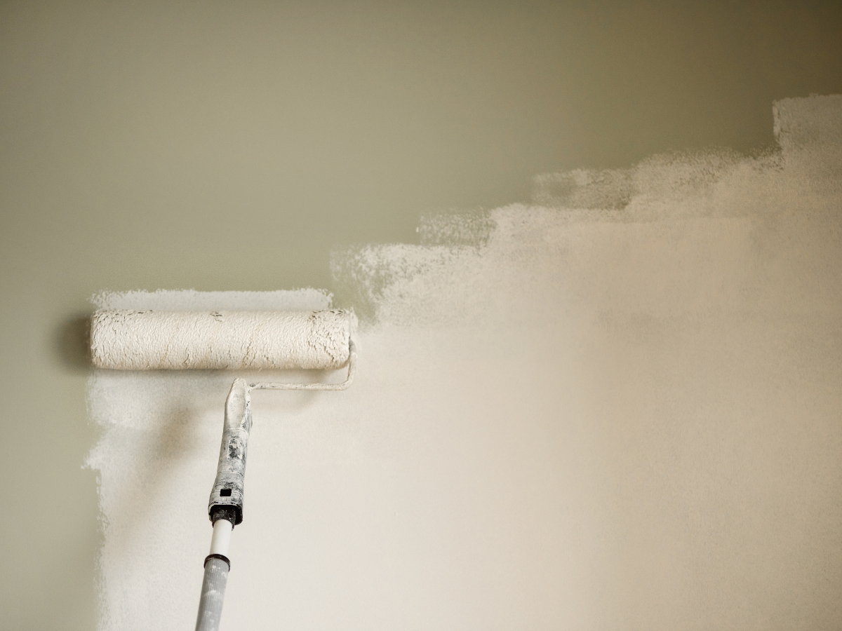 Fresh neutral paint being applied to an interior wall before selling a home