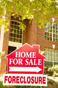 Foreclosure home for sale sign outside a house