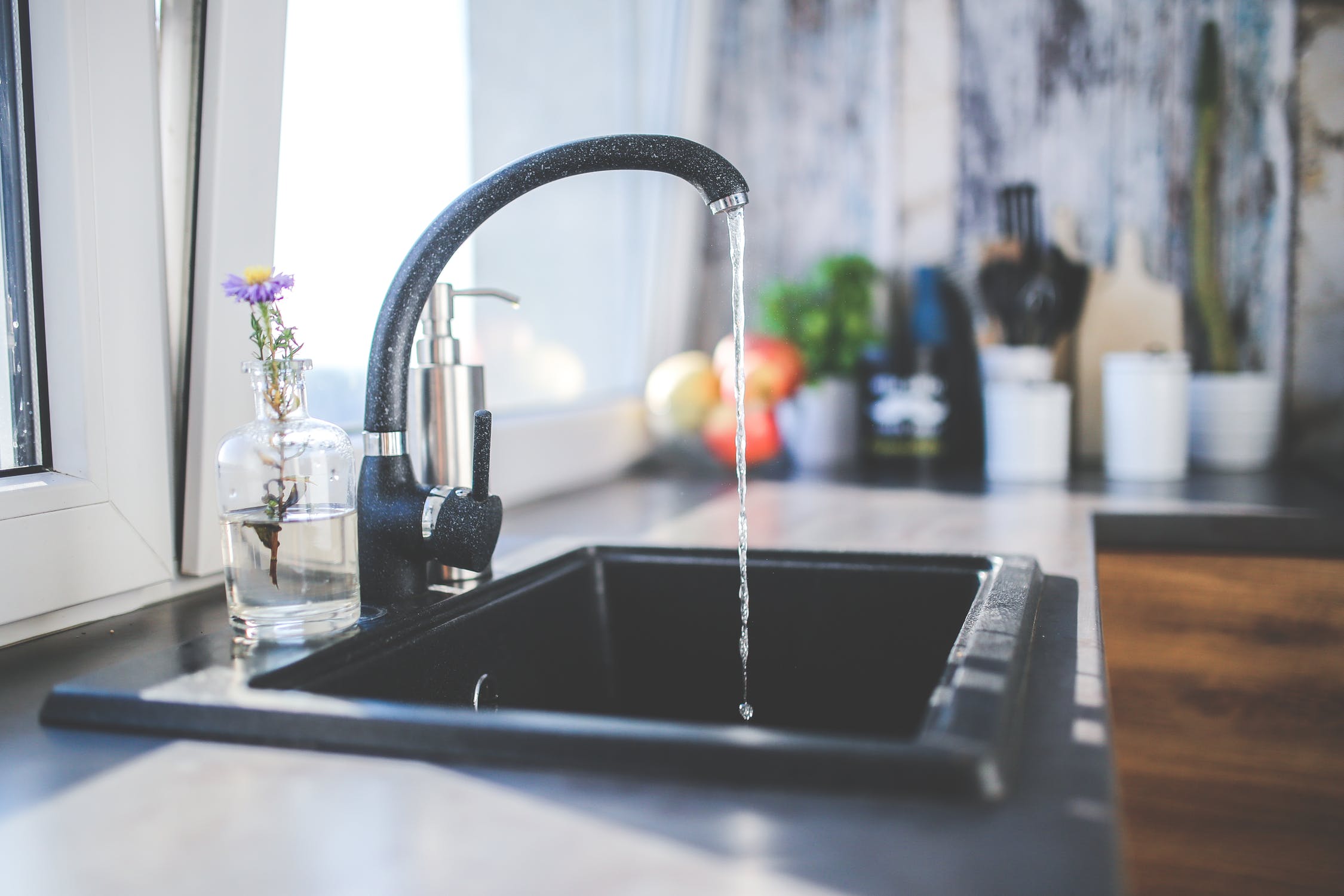 A kitchen sink with the water turned on.