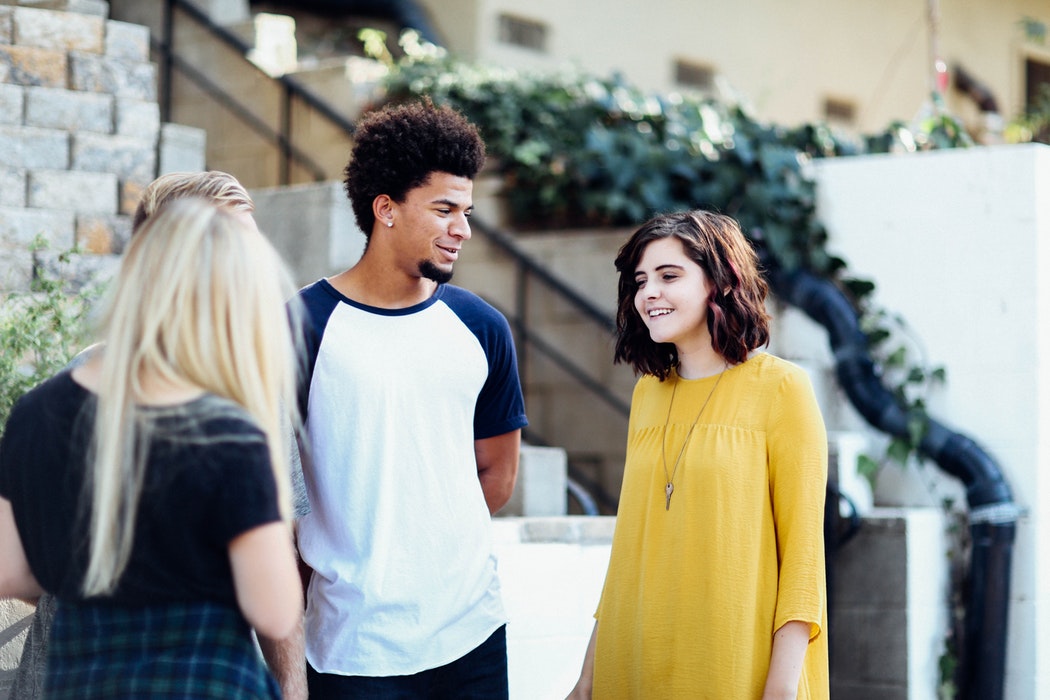 People talking in a group outside of a home.