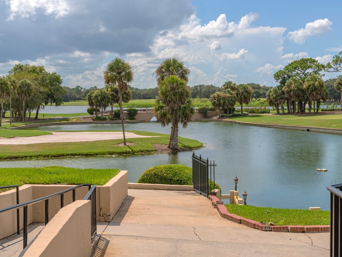 Golf course fairway beside a lake with palm trees