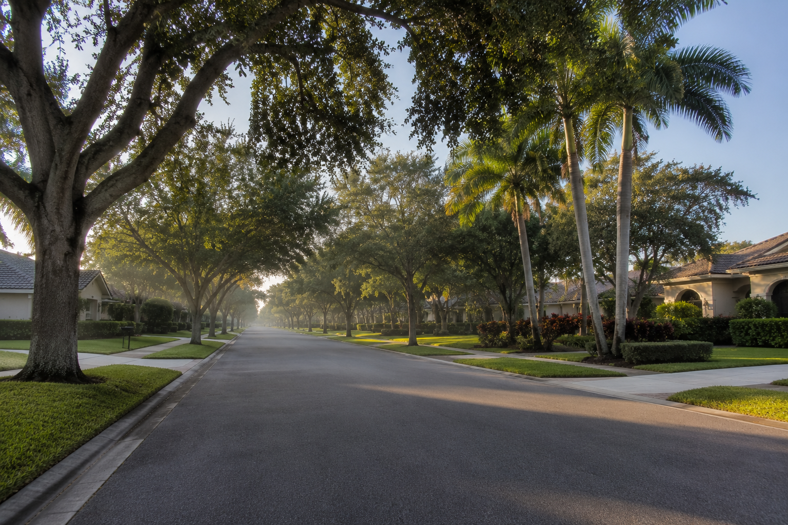 Residential street scene representing the geographic tradeoffs Palm Beach County families weigh when balancing school attendance zones, commute access and carrying costs. Supports a consumer-education blog asset on prioritizing competing constraints in a family home search