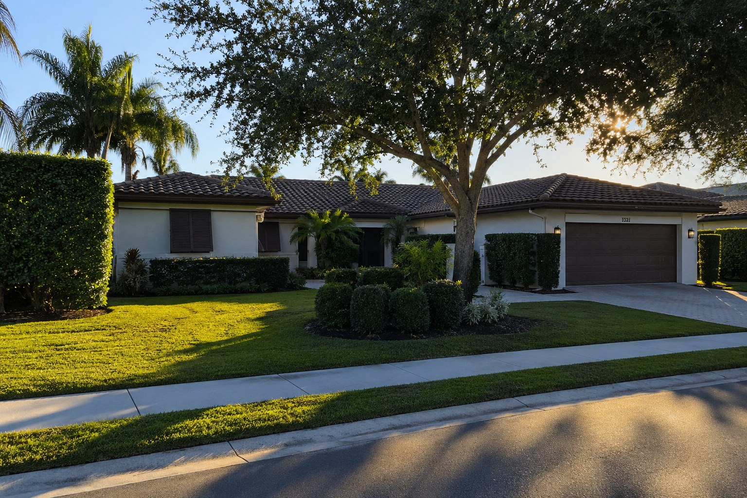 A photorealistic exterior scene of a well-maintained single-story residential home in Wellington, Florida, photographed during late afternoon with long horizontal shadows across the front lawn and an empty driveway. The image visually represents the strategic preparation window before a Palm Beach County home sale — the quiet, deliberate period between the decision to sell and market entry that determines seller positioning and outcome.