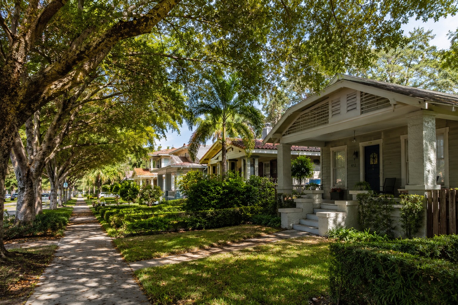 Tree-lined residential street in a West Palm Beach historic neighborhood with older bungalow homes and mature canopy