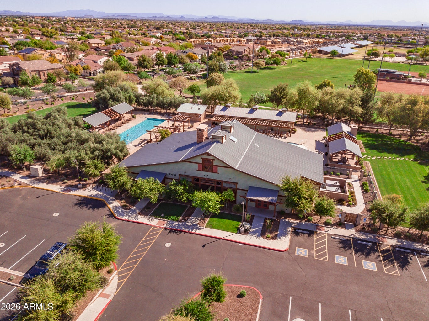 Aerial view of a Marley Park recreation building, pool, green space and surrounding homes