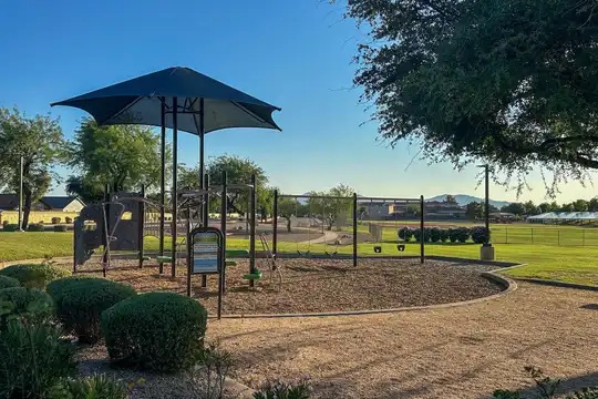 Shaded playground and green space in Kingswood Parke in Surprise Arizona