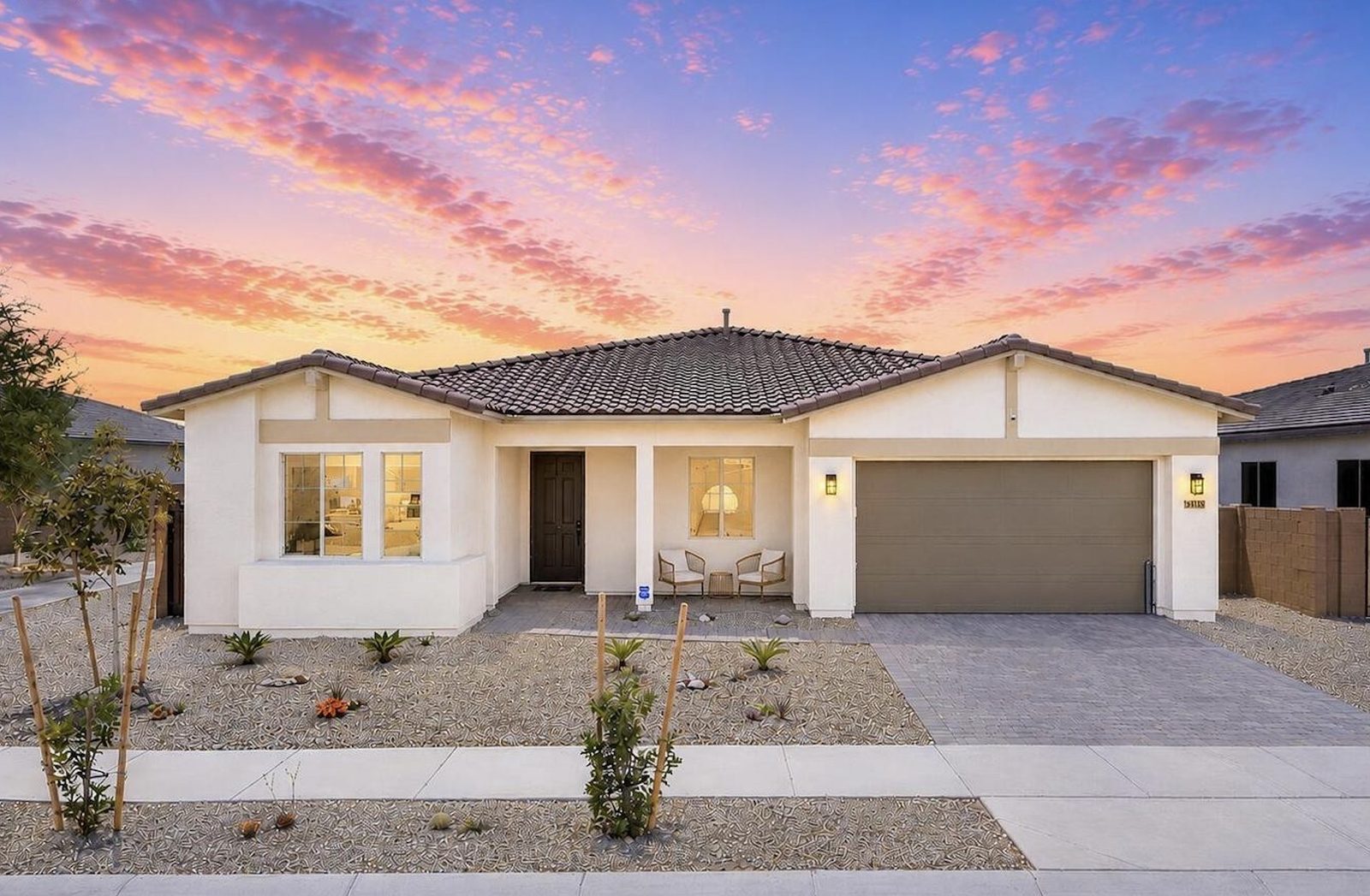 Single-story Rancho Mercado home with a paver driveway, tile roof and desert landscaping in Surprise Arizona
