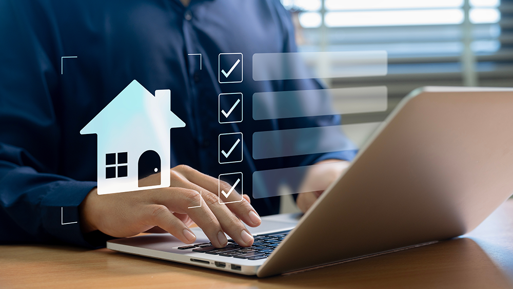 Person using laptop with house and checklist icons, symbolizing home selling strategy and preparation.