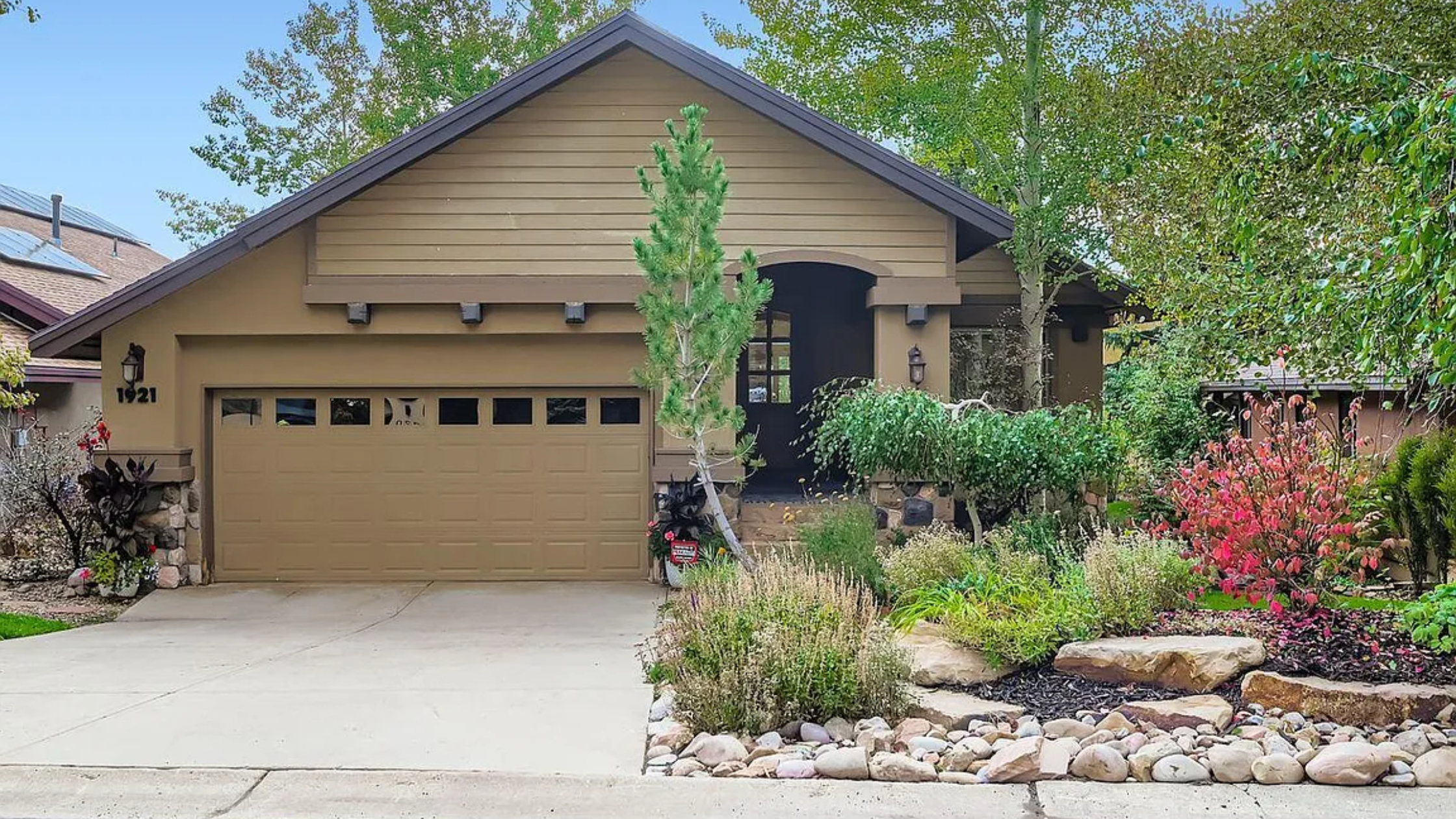 Front exterior view of 1921 Roffe Rd, a luxury home in Willow Draw Cottages, Park City, UT, featuring mature landscaping, a two-car garage, and timeless mountain architecture.