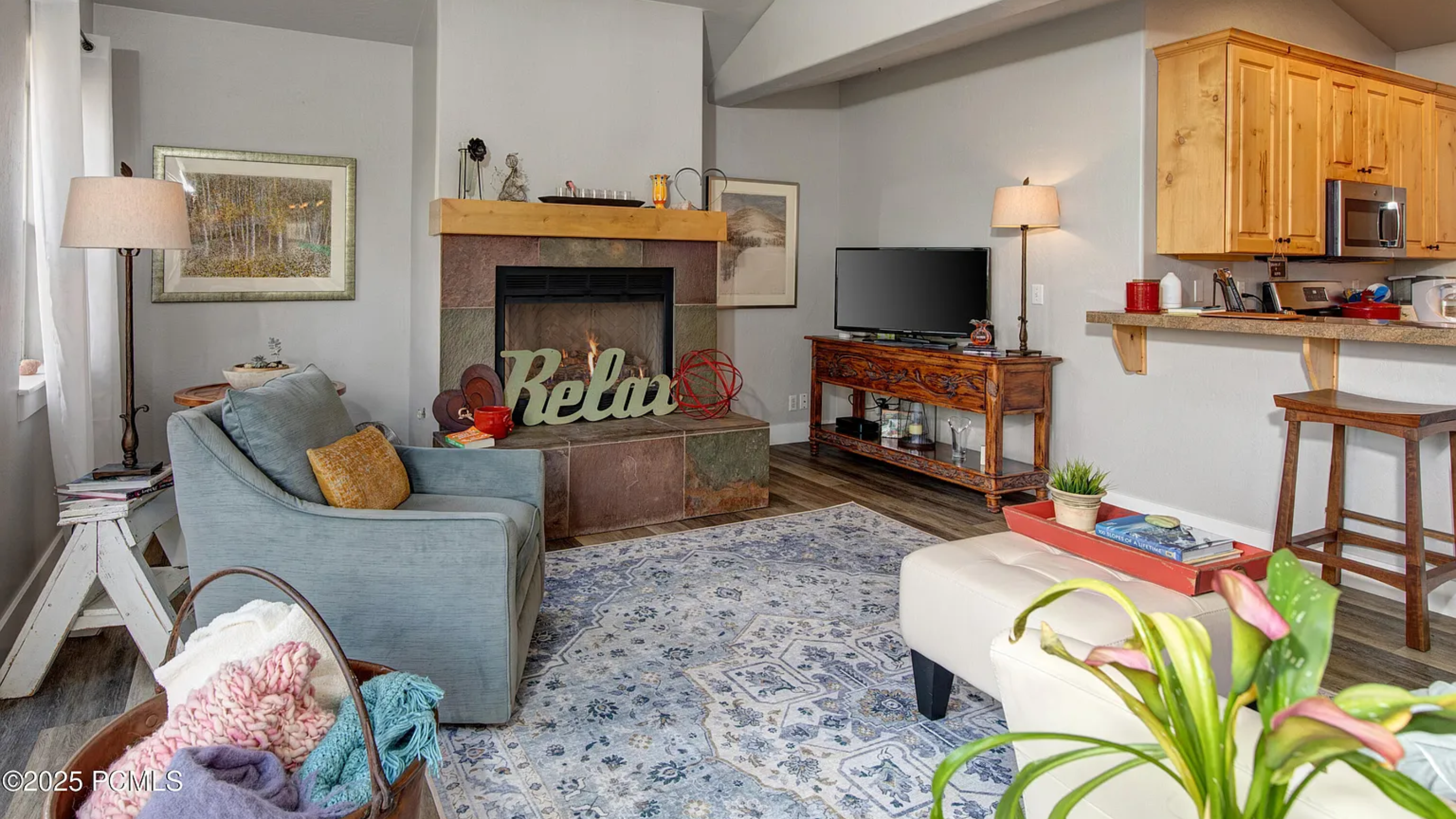Inviting living room at 5135 Cove Canyon Dr Park City condo for sale with a cozy fireplace, vaulted ceiling, and open connection to the kitchen and dining area.