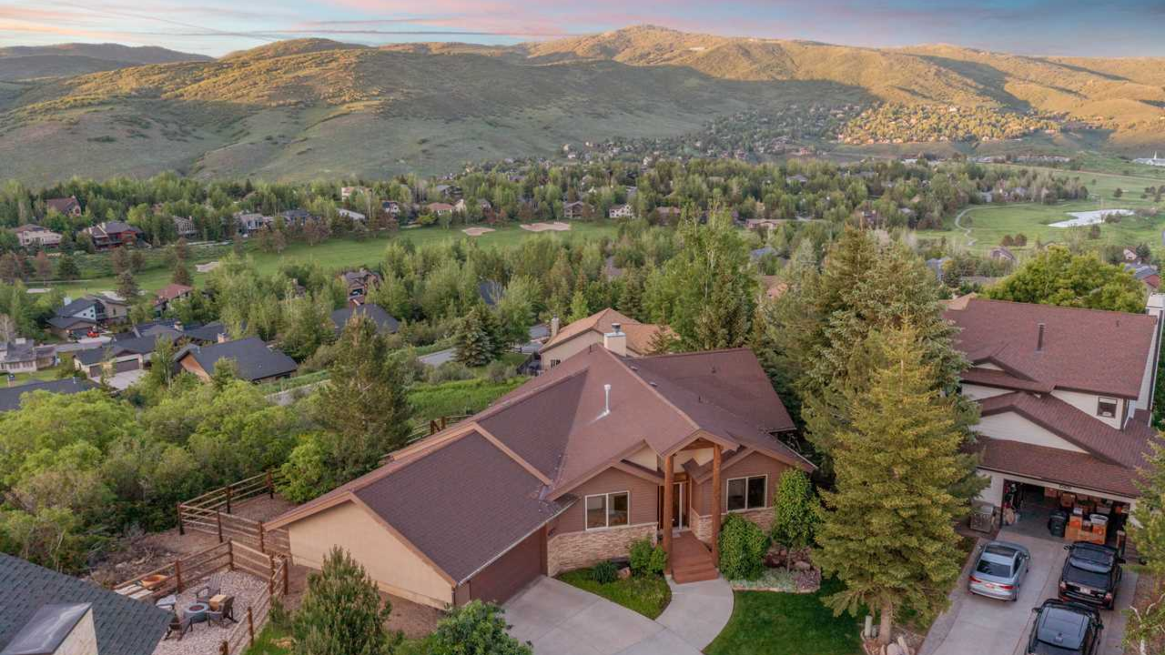 Aerial view of homes in Jeremy Ranch Utah surrounded by trees and golf course with mountain backdrop