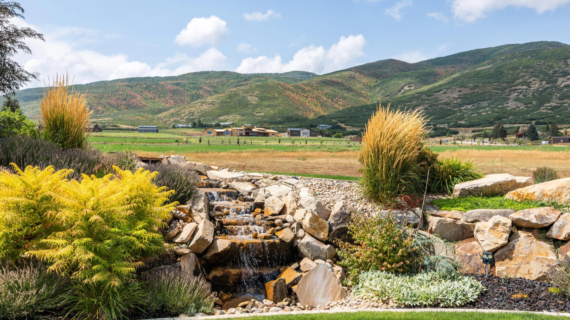 Scenic view of Midway, Utah real estate trends showing luxury homes, open green fields, and mountain backdrops highlighting the area's lifestyle and market growth.