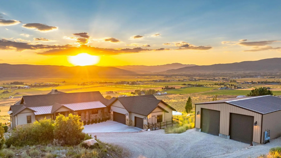 Luxury home in Kamas, Utah at sunset overlooking open fields and mountain views, highlighting the Kamas Utah housing market 2025 and growing real estate trends.