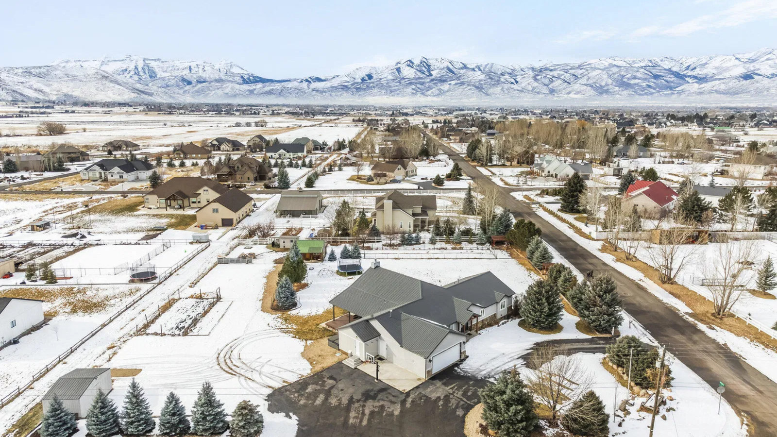 Snow-covered homes and open lots in Heber East, Utah with mountain views.