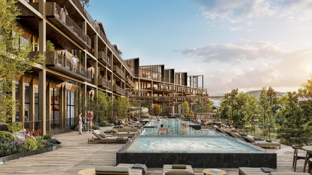 The resort pool terrace at The Slope in Heber, featuring sun loungers, landscaped decks, and views of the surrounding mountains in summer.