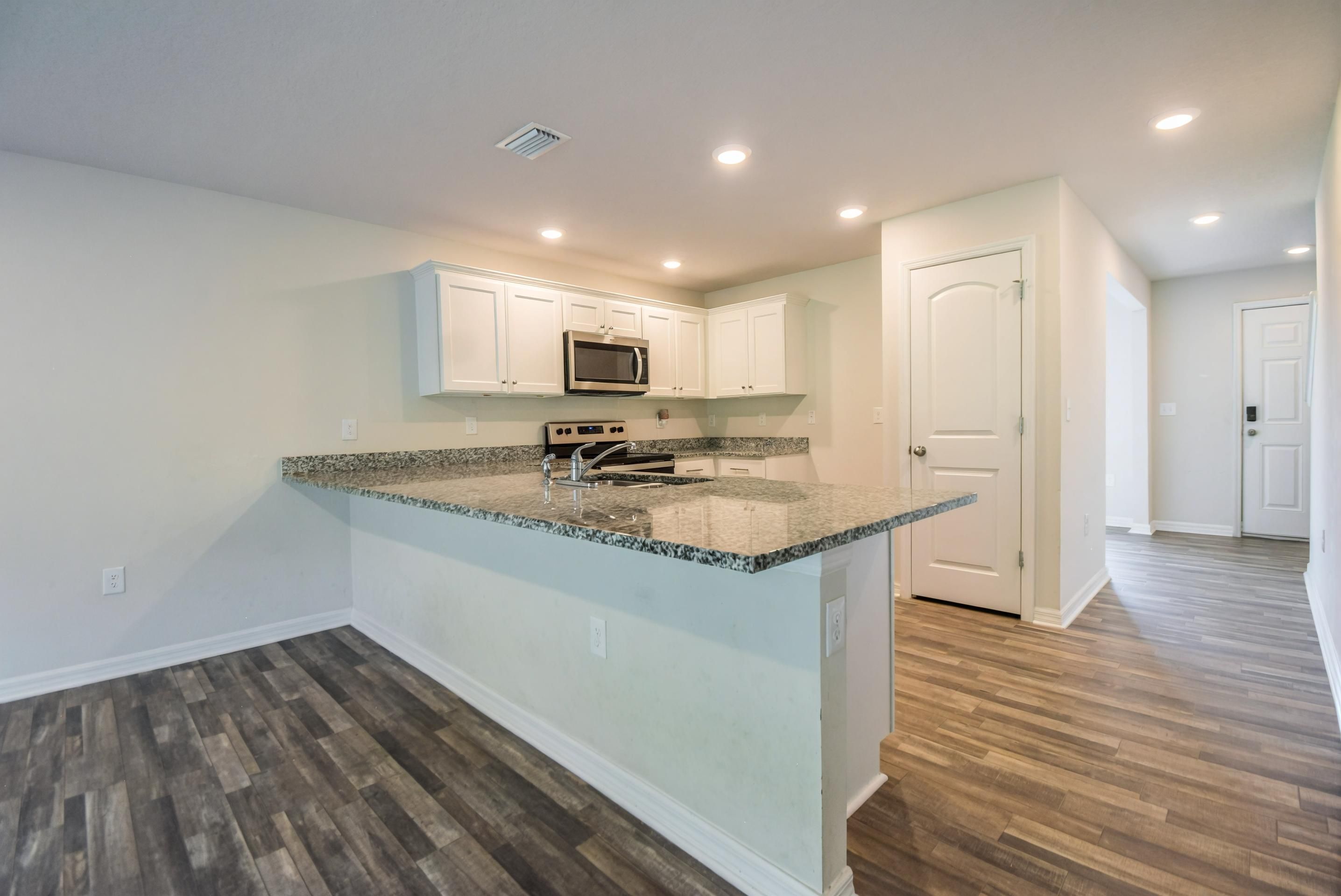 Kitchen with granite countertops and white shaker cabinets at 205 River Hill Drive