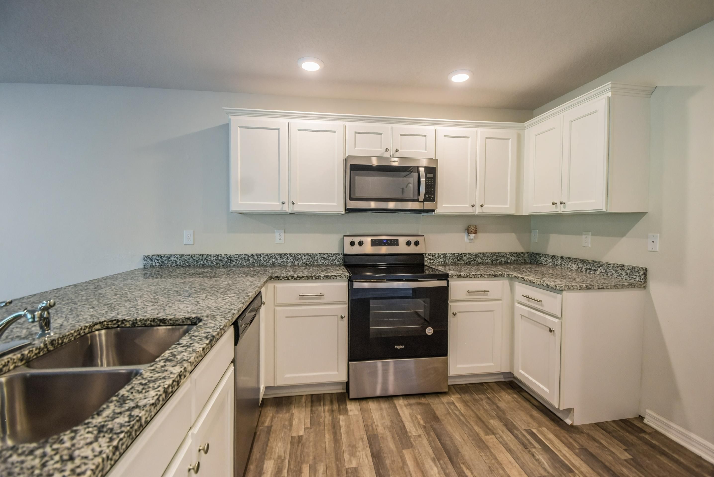Kitchen with white cabinetry and granite countertops
