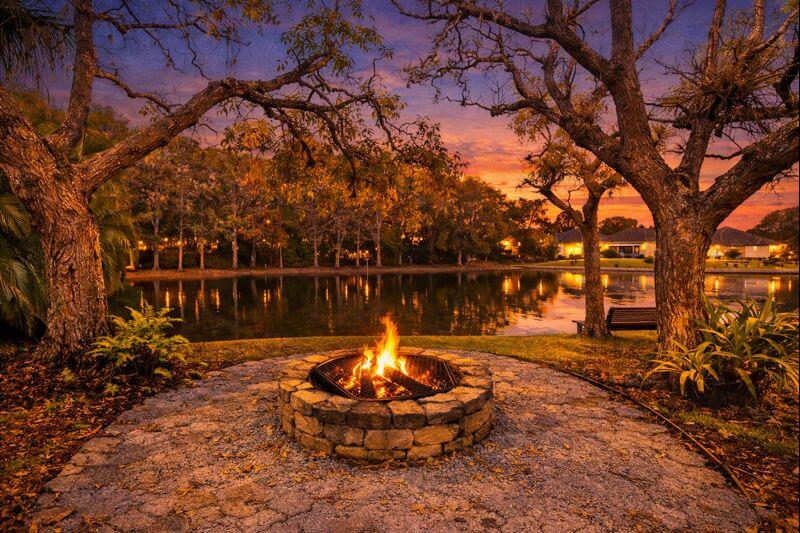 Lakeside fire pit at sunset behind a Lake Worth Florida lakefront home in Woods Walk 2
