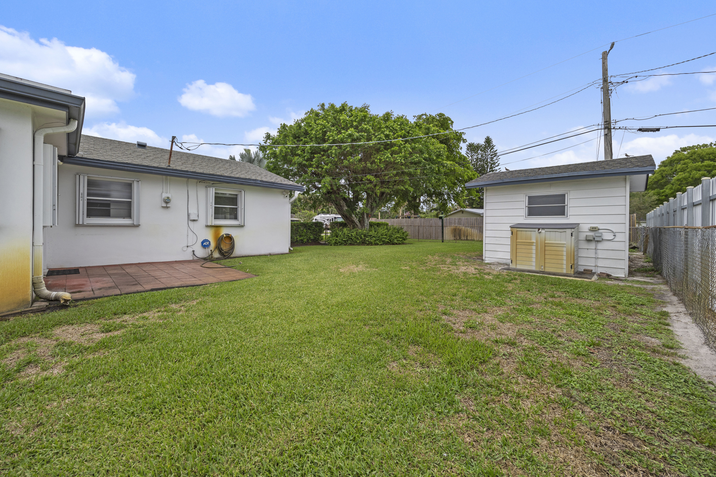 Fully fenced backyard with two storage sheds at 5557 S Shadyside Circle West Palm Beach Florida no HOA