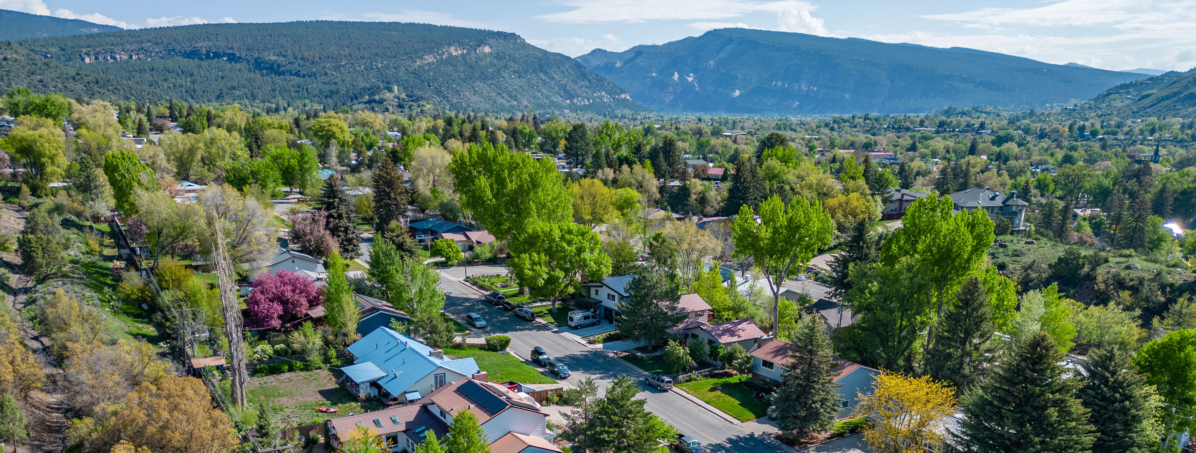 Aerial view over an in town Durango, Colorado residential neighborhood in spring, with the valley and surrounding mesas behind it