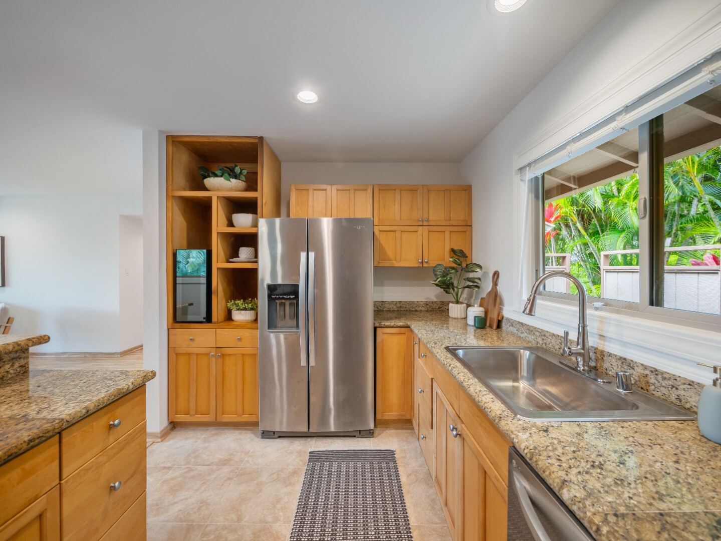 Kitchen details with travertine tile, maple cabinets, granite counters, stainless appliances, wine fridge